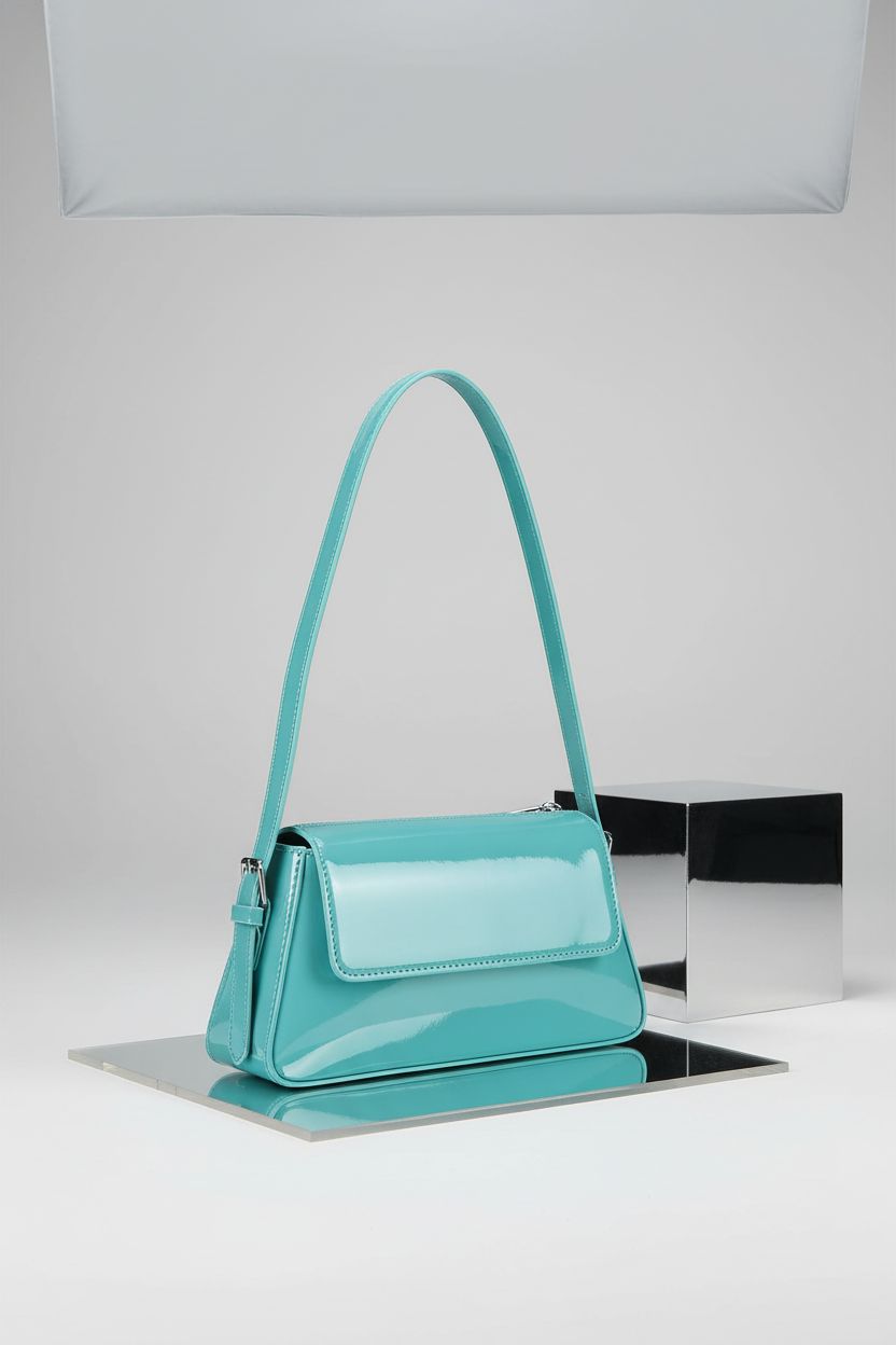 Youjaree aqua handbag on seamless backdrop, highlighting its glossy finish and design.