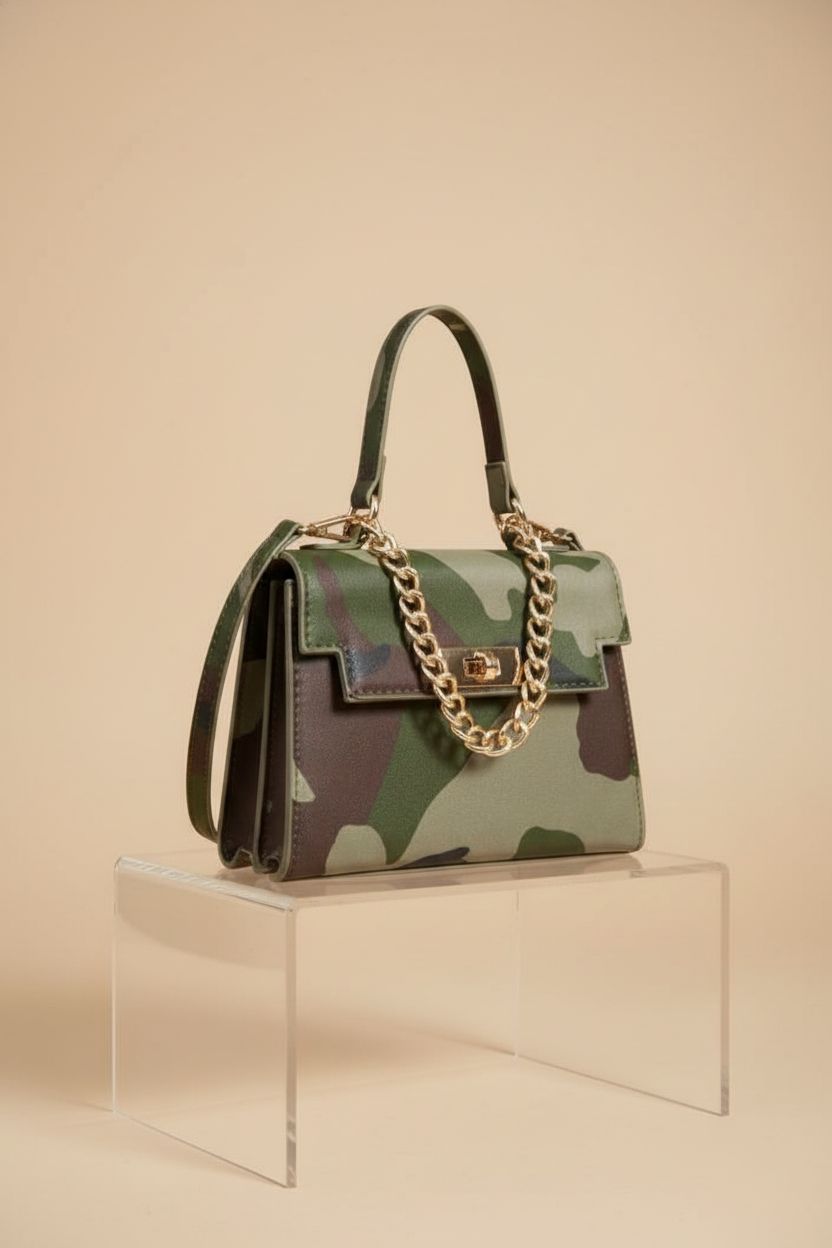 Close-up of RoseSeek camo purse on acrylic riser, showcasing details and gold chain.