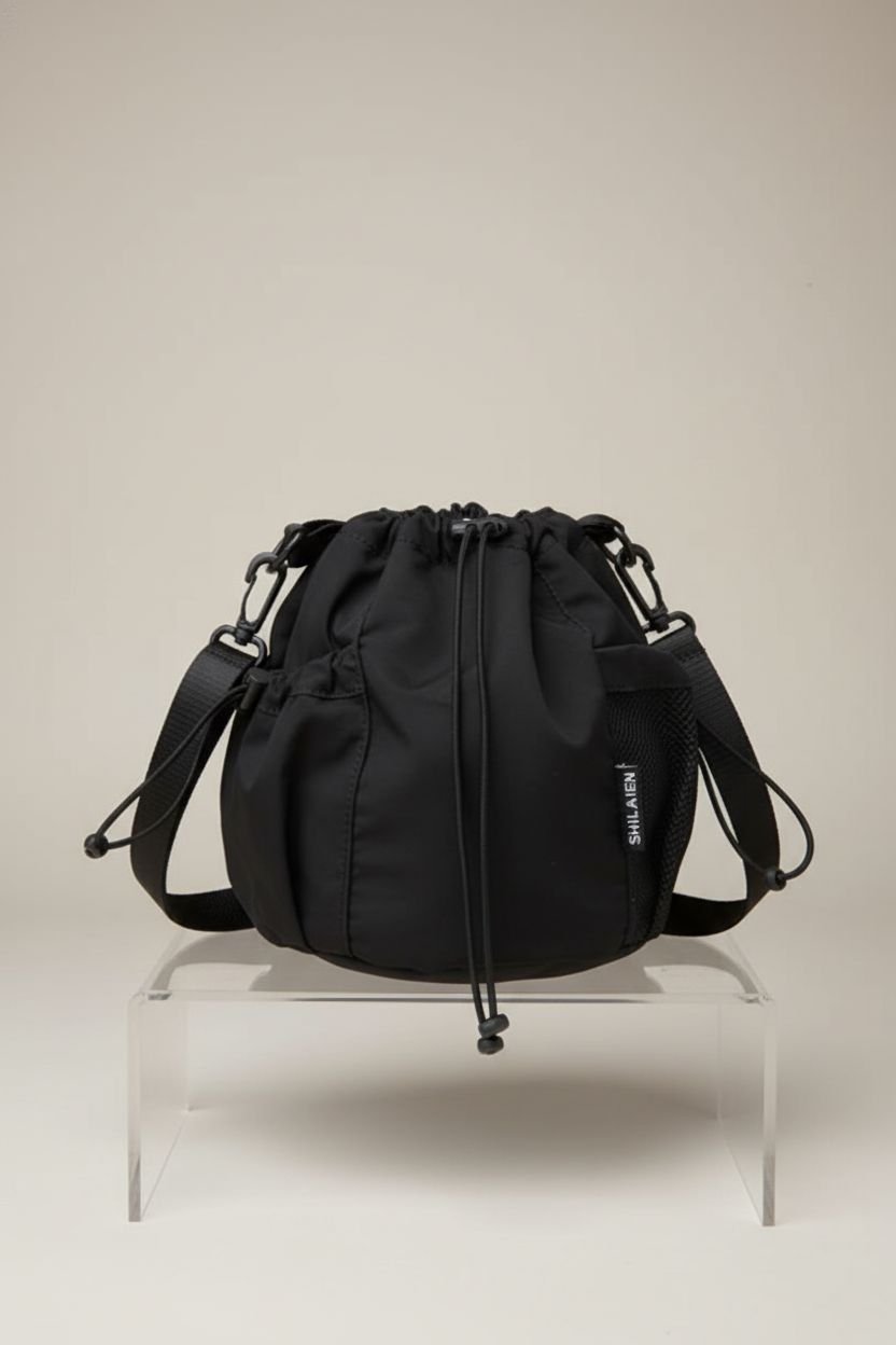 TWOYOMN black nylon crossbody drawstring bag on display, highlighting its sleek design and texture.