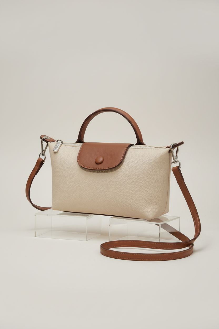 VesaNa Yoolo off-white quilted crossbody bag displayed on an acrylic block in studio.