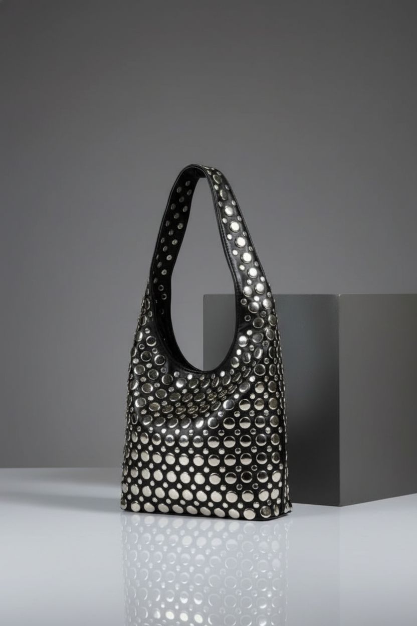 Close-up of Jusavie's studded hobo bag highlighting PU leather and elegant design on a sleek background.