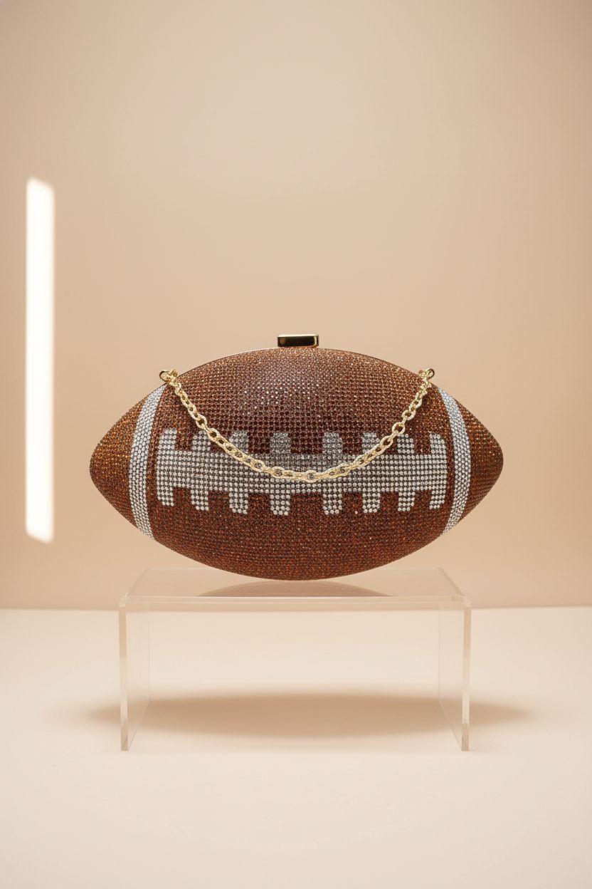 ARTLUXE football purse on an acrylic riser, highlighting its detailed rhinestone design and elegant chain.