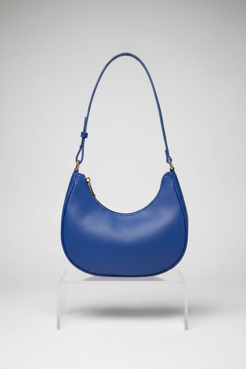 WSRYDJDL royal blue crescent bag showcased on a minimal acrylic display in a studio.