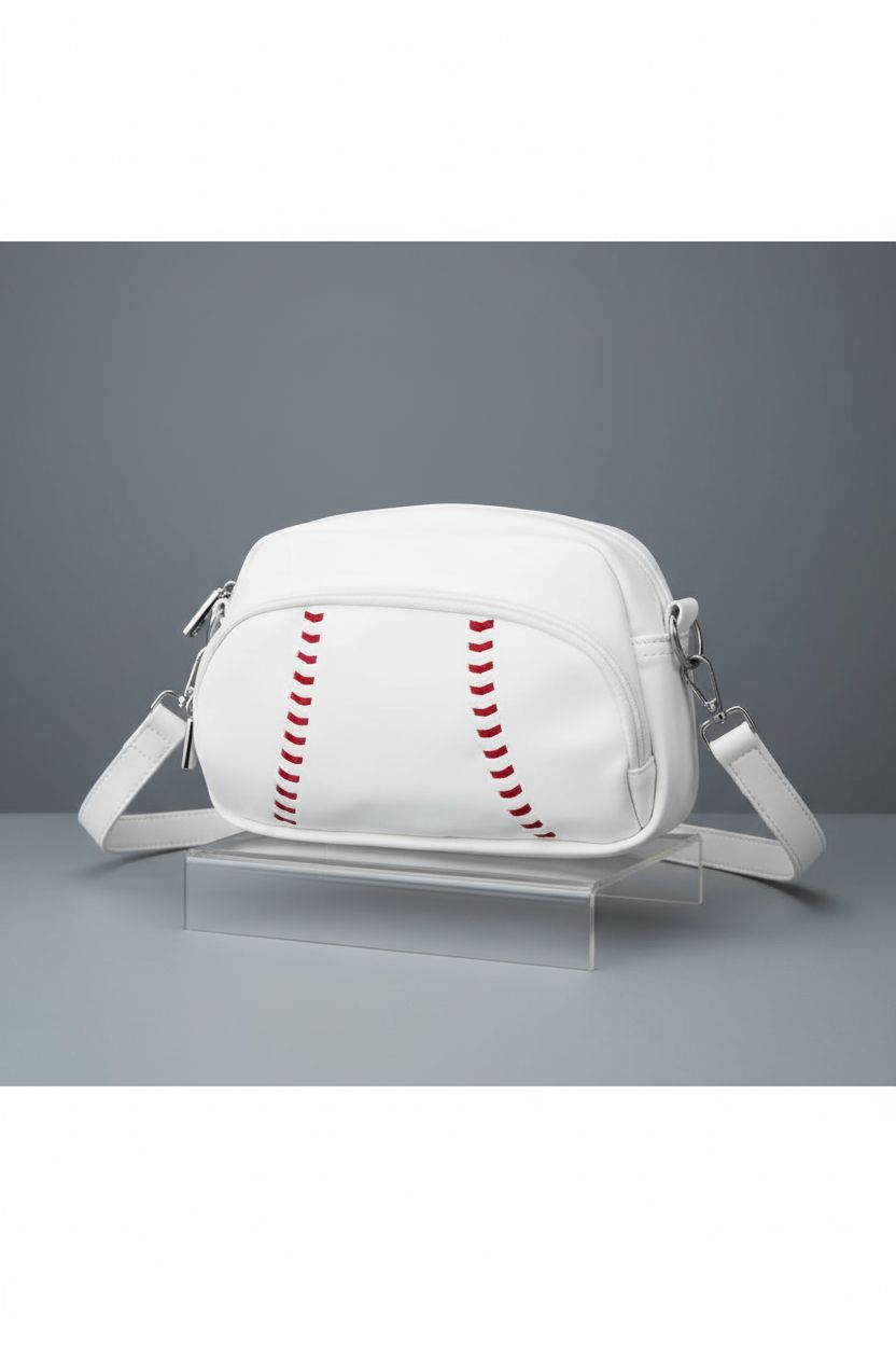 Product shot of Halftime Handbags baseball crossbody purse on gray backdrop.