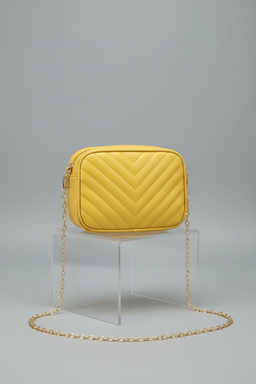 Detailed view of yellow satchel by Generic, showcasing quilting and structured design