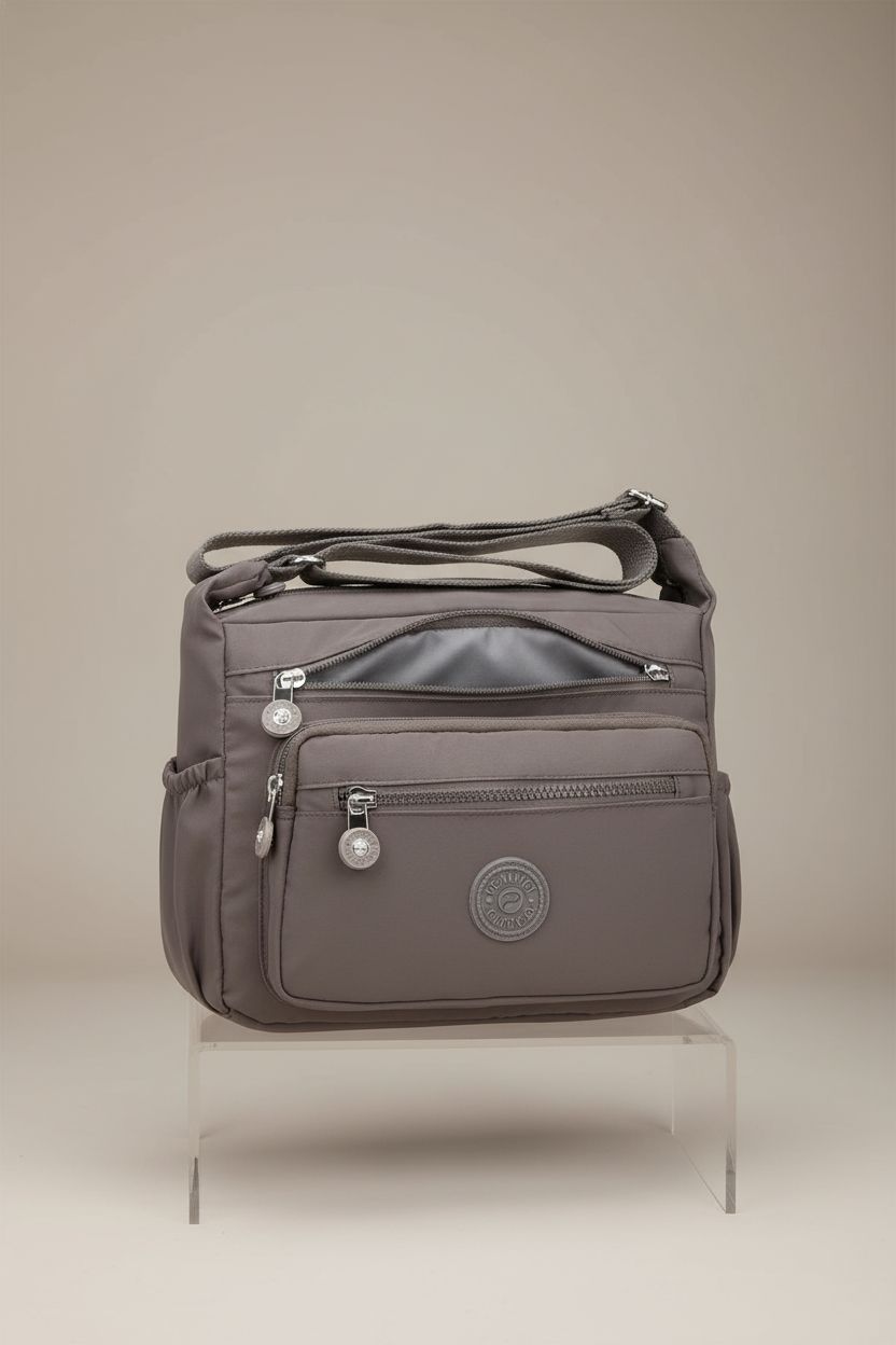 Pealwel women's handbag in grey displayed on a clear riser, emphasizing its roomy compartments and sleek design.