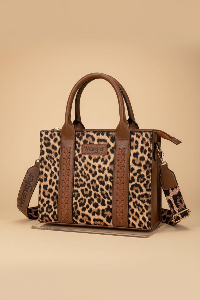 Elegant Wrangler leopard print tote bag displayed on acrylic riser in studio.