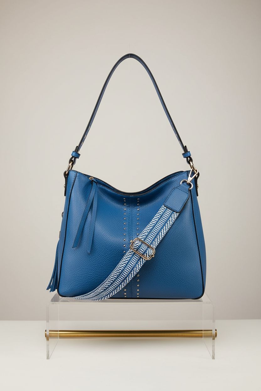 Montana West cobalt-blue hobo bag displayed elegantly on an acrylic stand, highlighting its design features.