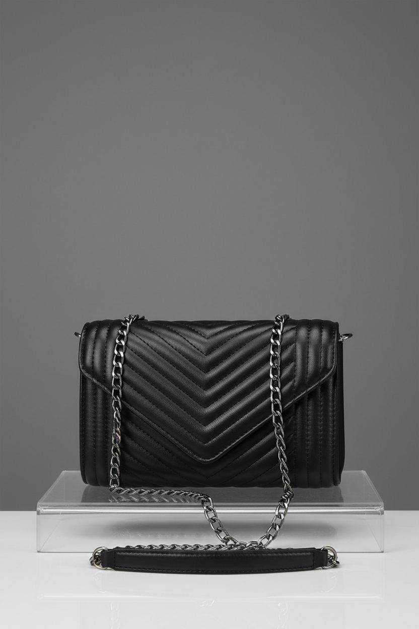 Product shot of Voikukka matte black crossbody bag highlighting its design and chain strap.