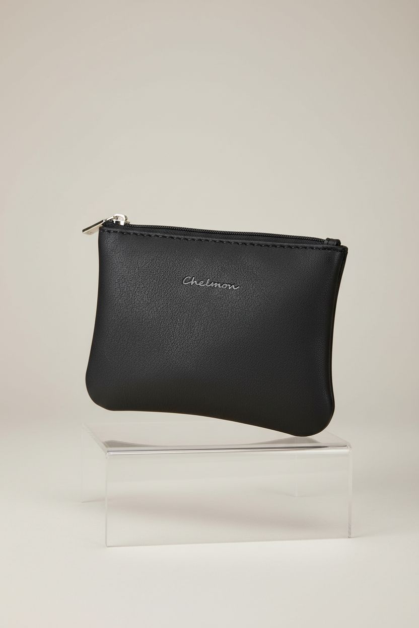 Close-up of black Chelmon mini coin purse on a studio set, showcasing its vegan leather and zipper features.