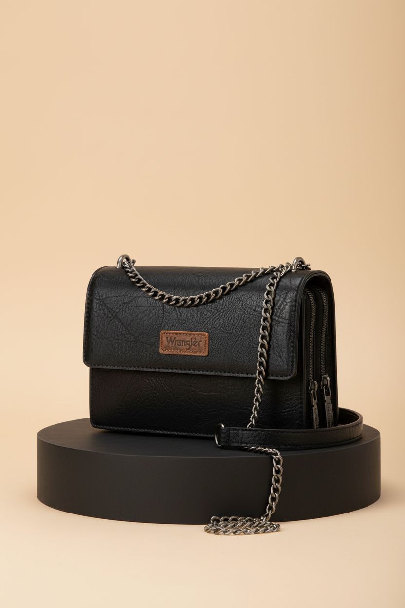 Black Wrangler CrossBody Purse displayed on matte black plinth, highlighting its sleek design and craftsmanship.