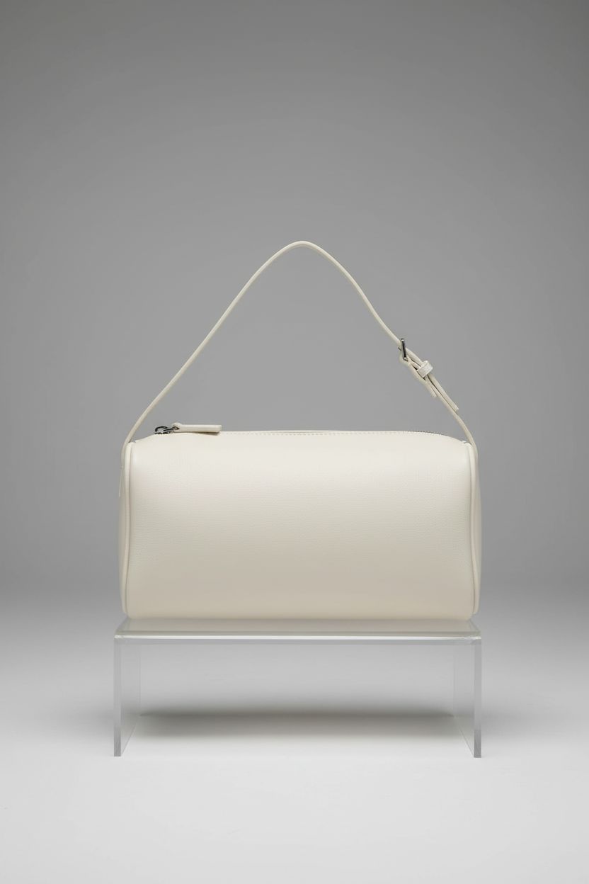 Elegant white DONNAIN crossbody purse displayed on acrylic, highlighting premium leather craftsmanship.