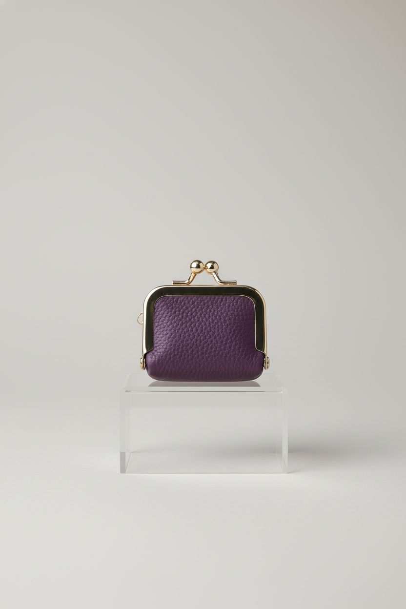 Product shot of Royal Bagger deep purple mini coin purse against warm gray backdrop, highlighting design.