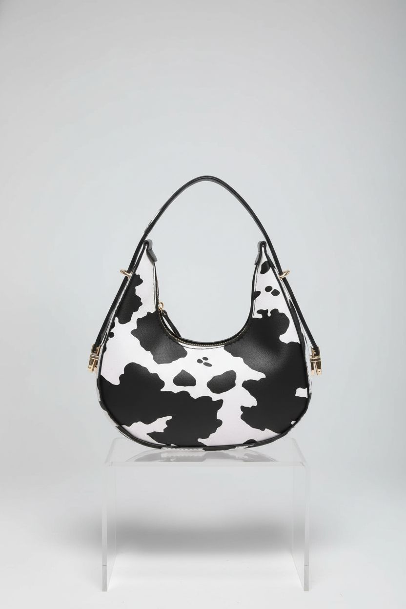 Product display of PURFANREE cow print clutch purse on a sleek backdrop, highlighting design.