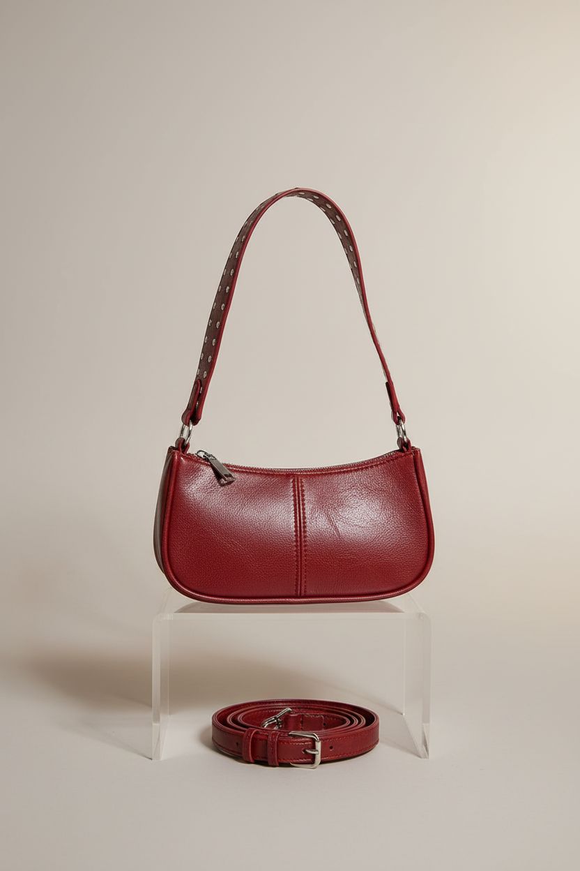 GETERUUV burgundy studded shoulder bag displayed on a minimal acrylic riser.